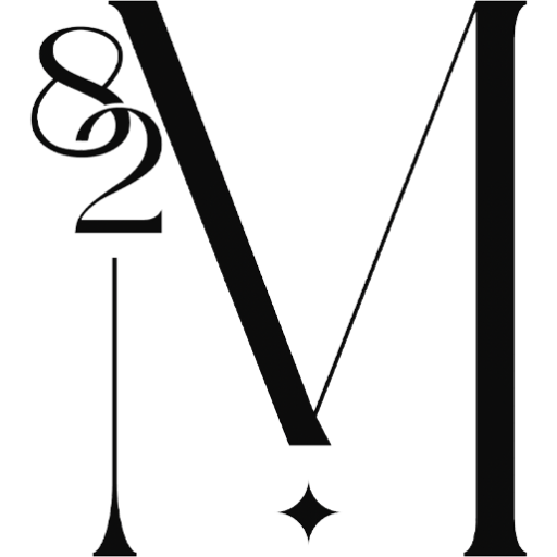 Black stylized serif letter M monogram with ornamental ampersand flourish and small star accent